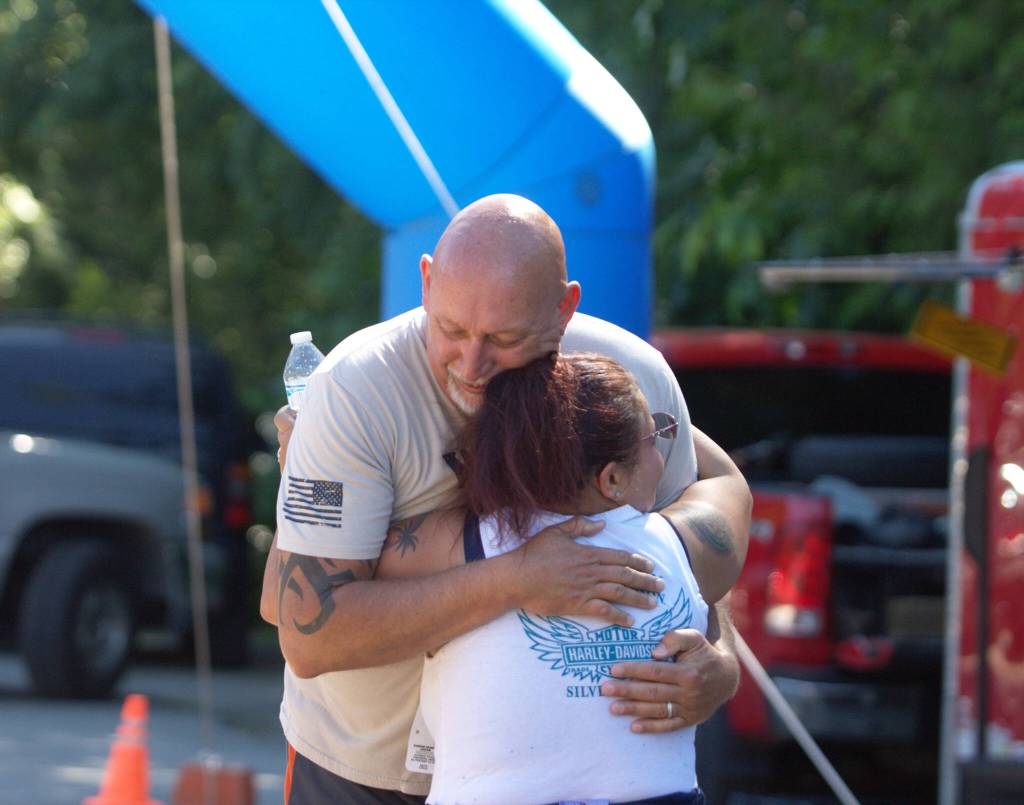 A couple hug each other just past the finish line of the Hotfoot 5k after finishing the race.