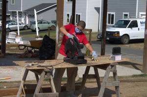 One of the volunteers cuts some of the wood being used for the community playground. Elisha Meyer/Port Orchard Independent Photos
