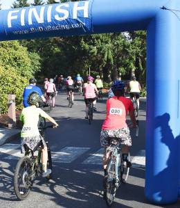 Bicyclists cross the finish line at the event to race money for refugees. Courtesy Photo