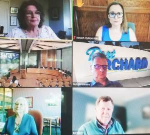 The health board met in person for the first time in 2 1/2 years, left center. On Zoom were, clockwise, Poulsbo Mayor Becky Erickson, Bainbridge City Councilmember Kirsten Hytopoulos, Port Orchard Mayor Rob Putaansuu, and County Commissioners Ed Wolfe and Charlotte Garrido. Steve Powell/Kitsap News Group