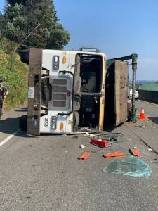 The garbage truck lies on its side after tipping over due to a flat tire. Courtesy Photo