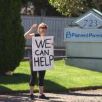 A protester waves to cars passing by the Planned Parenthood in Bremerton. Elisha Meyer/Kitsap News Group