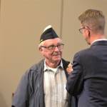Rep. Derek Kilmer puts a commemorative pin on one of the veterans.