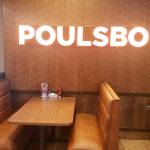 A vibrant Poulsbo sign above one of the booths at Dennys.