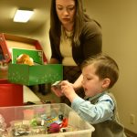 Rachel Garaard helps her son, Luke, 3, fill a box with items for Operation Christmas Child. Nancy Treder/Kitsap News Group Photos