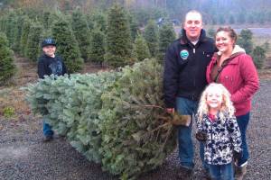 Adam and Sarah Stuart, with their kids Ethan and Caitlin, show off their prize Christmas tree. Olmsted Tree Farms Courtesy Photo