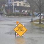 Signs on the road warn drivers of upcoming water and road closures.