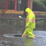 A city worker picks up debris swept up by floodwaters. Elisha Meyer/Kitsap News Group Photos