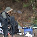 A homeless person sits among the filth of the camp along Bethel Avenue. Elisha Meyer/Kitsap News Group Photos