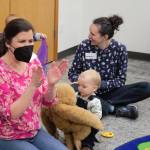 Youth services librarian Nell Ramsay leads her group in a song.