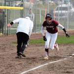 Junior Kamdyn Hagerty high-fives her third-base coach while rounding the bases on a game-tying solo home run.