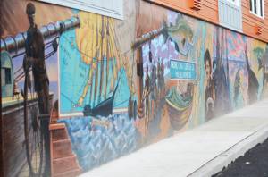 A historic mural signed by artist Steffon Moody brightens up a side of a new housing structure being built just off Front Street in downtown Poulsbo. Steve Powell/Kitsap News Group
