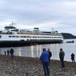A crowd of curious people gathers on Pleasant Beach to see the Walla Walla ferry that ran aground during low tide.