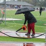 A leaf blower is used to remove standing water from the discus ring.