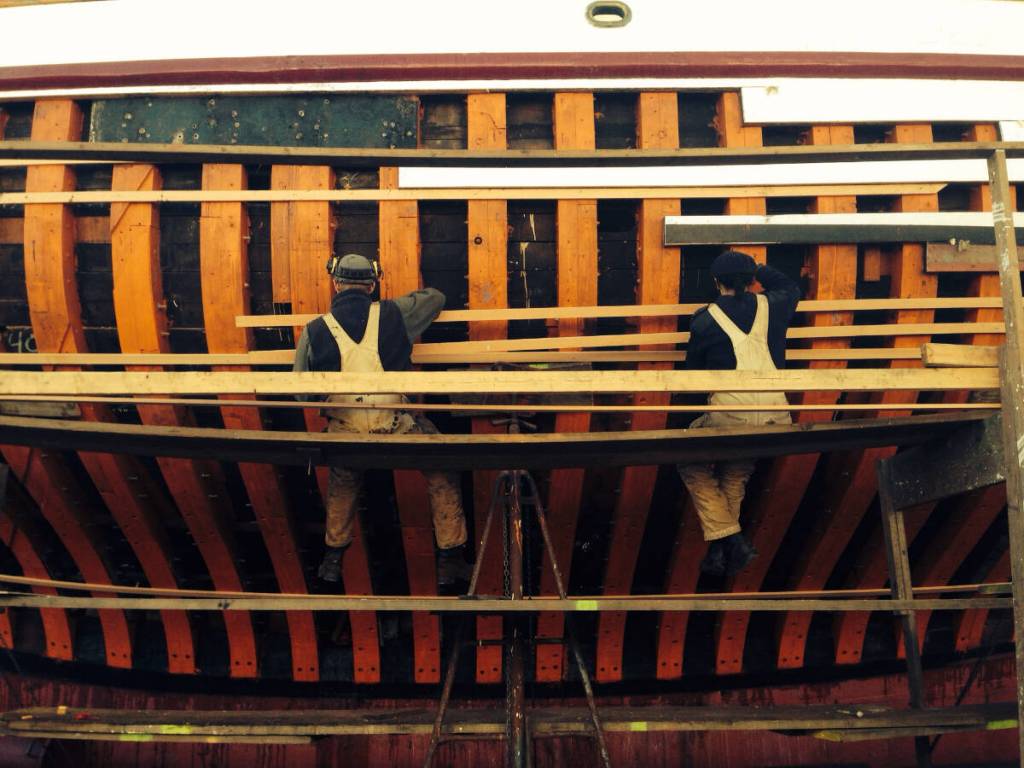 Crew at Haven Boatworks working on the side of a ships hull. Photo courtesy First Fed