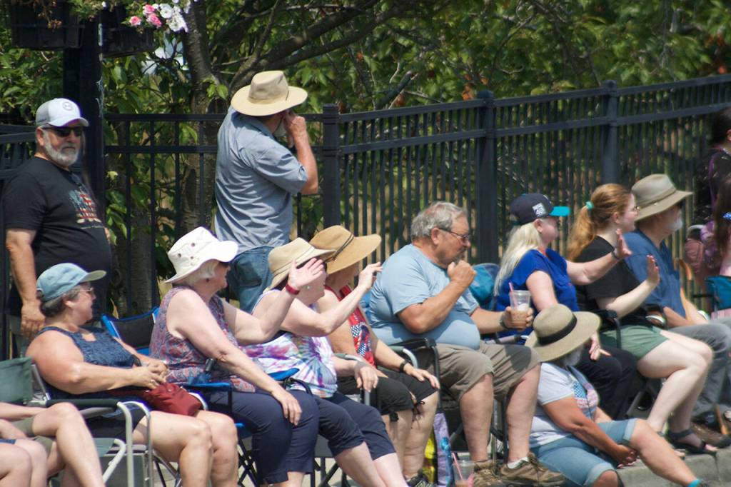 Parade-goers wave to the attractions making their way through downtown Kingston.