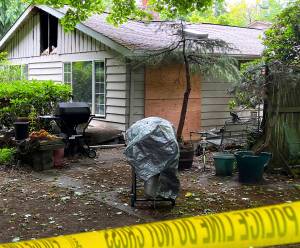 Caution tape surrounds a home on Sunrise Drive that caught fire June 29 and claimed the life of Charles J. Adolfson. Nancy Treder/Kitsap News Group