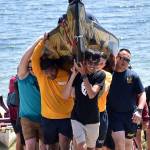 Canoes are carried up the ramp by tribal members and volunteers from the Navy.