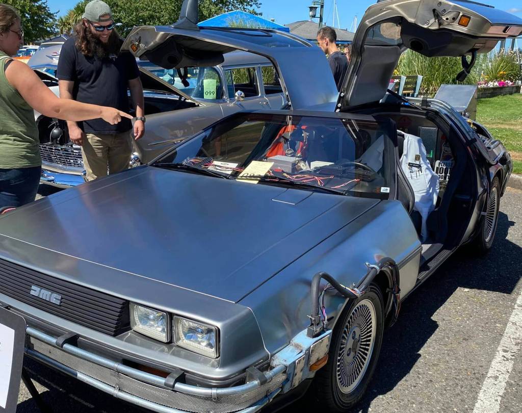 Attendees of the Saints Car Club Car Cruz in 2022 get an up-close look at a 1981 DeLorean.