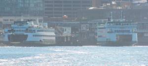 Ferries from Bainbridge Island, left, and Bremerton pull into the updated ferry Colman Dock in Seattle Aug. 3. Two new elements of the project opened that day -- the entry building along Alaskan Way and the elevated pedestrian connector that leads to the passenger terminal building. Steve Powell/Kitsap News Group