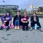 Seniors sit on the beach at Manchester as first light creeps into the day.
