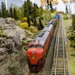 A model train zooms down one of the tracks.