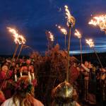 Vikings prepare to light the bonfire with their torches.