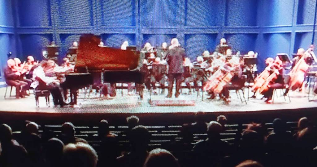 The symphony on stage, featuring Alec Rodriguez, left.