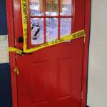 Shattered glass from the front door covers the store floor.