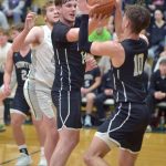 North Kitsaps Logan Hudson, center, and Cade Orness, right, grab a rebound as Port Angeles Isaiah Shamp, left, looks on during Tuesday nights game at Port Angeles High School.