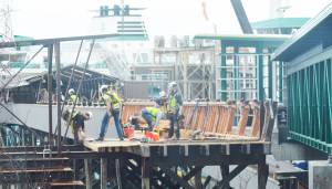 Steve Powell/Kitsap News Group Photos
A big group of workers is tearing down the old ferry passenger overpass on Bainbridge Island as the new one at right is now operational.