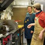 Chefs work inside the food truck.