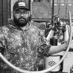 Vinay Vaithianathan, a Watson production operator, holds a bent steel tube produced by the new Elect 52 Steel Tube Bender. The tooling produces Havens signature footrail.