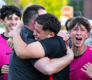 Elisha Meyer/Kitsap News Group photos
Central Kitsap soccer coach Patrick Leonard and junior Joshua Voce embrace, surrounded by cheering teammates after Voces game-winning shot.