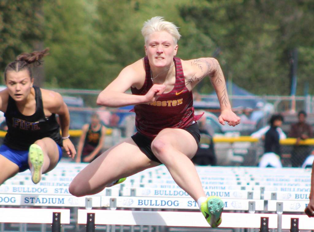 Kingstons Leighton Menge flawlessly passes over the last hurdle in the 100-meter race.