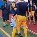 Finn Reynolds (11) proudly stands next to the BHS bench as his teammates celebrate the win.