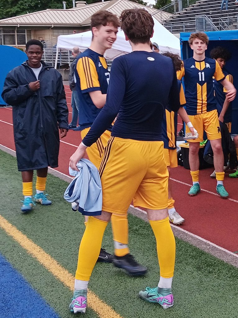 Finn Reynolds (11) proudly stands next to the BHS bench as his teammates celebrate the win.