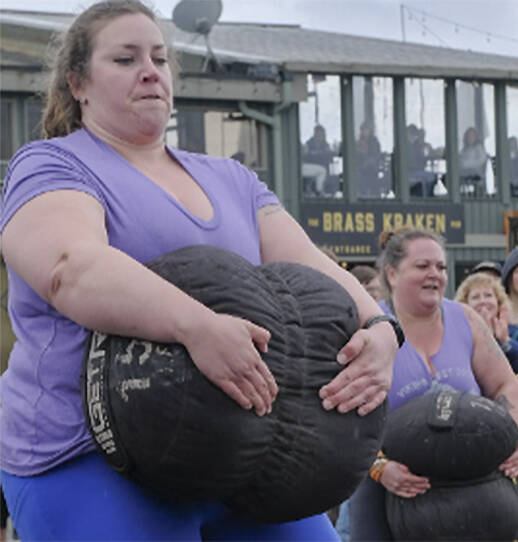 Christina Tangelin totes a 150-pound sandbag as the last part of the Pillage Series event in the Strongest Woman competition.