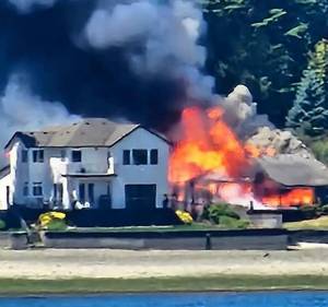 Andrea Powell courtesy photo
Smoke and flames erupt from a three-alarm house fire on Erlands Beach Loop NW June 6.