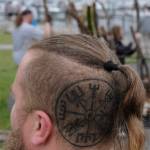 Damon Williams/Kitsap News Group photos
Brennan Webster shows his tattoo as others build the bonfire in the background.