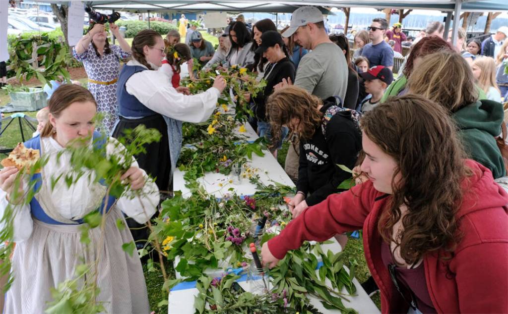 Folks work with greenery to make decorations for the festival.