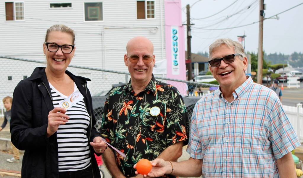 Matt Carter stands between the $500 Great Ball Race winners Karen and Chuck Rider.