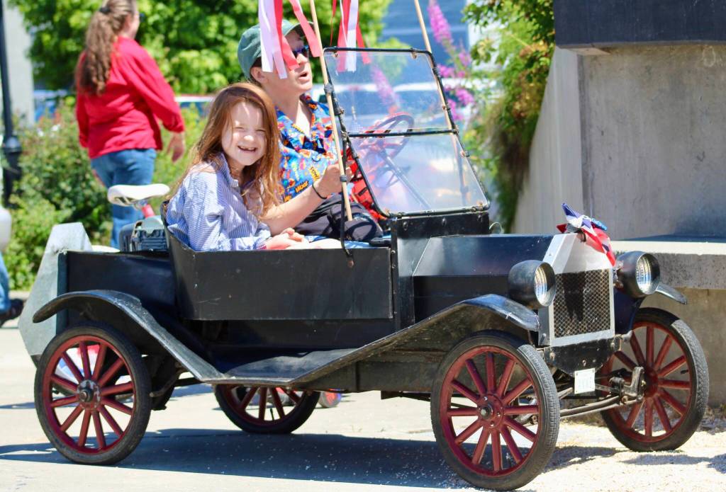 A mini Model T helps lead the way in this years parade. Otto, in front, had plenty of fun in the passenger seat.