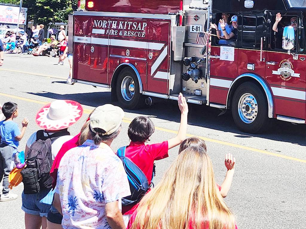 Firefighters waive to community members as they make their way through the parade.