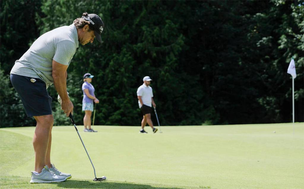 Retired Mariners infielder Brett Boone lines up a putt.