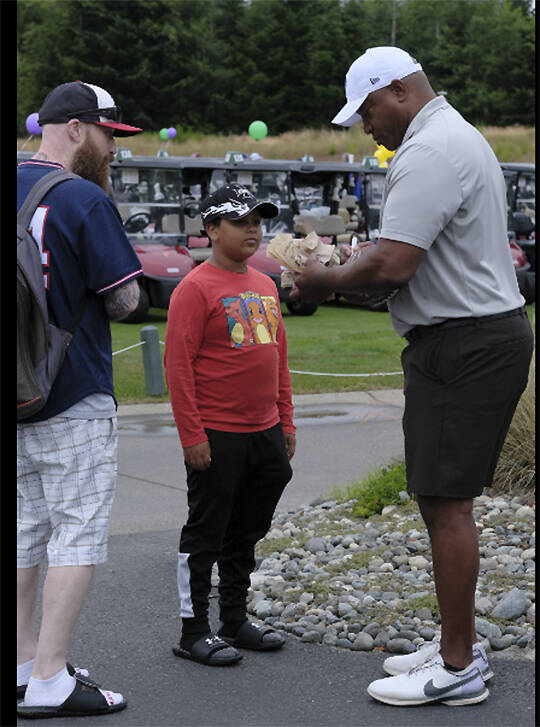 Ex-Seahawk fullback Mack Strong signs an autograph at the event.
