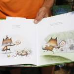 Bill Knopp displays a page from the hit childrens book series, Pickleball Paul, in which a young fox learns valuable life lessons while playing pickleball.