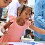 Nalani Bannis, 7, makes a sign for the sailors coming home to Bremerton.