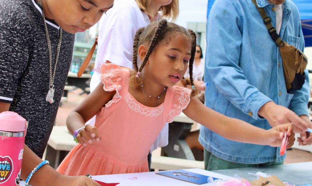 Nalani Bannis, 7, makes a sign for the sailors coming home to Bremerton.