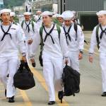Sailors file off the USS Ronald Reagan and walk to their new home of Kitsap County.